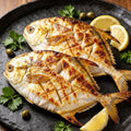 Grilled whole golden pomfret with char marks and lemon